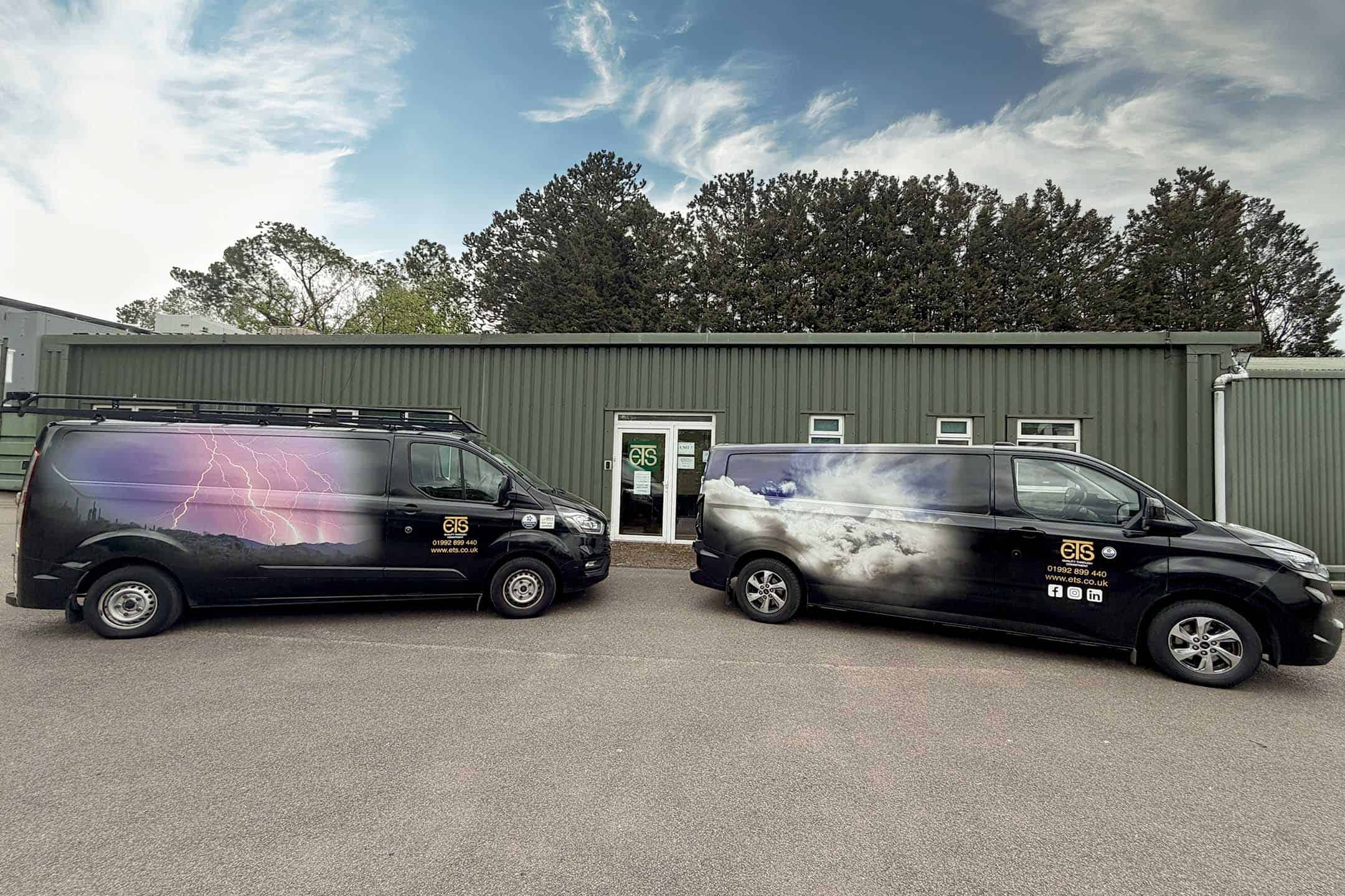 Two ETS vans in front of their building.